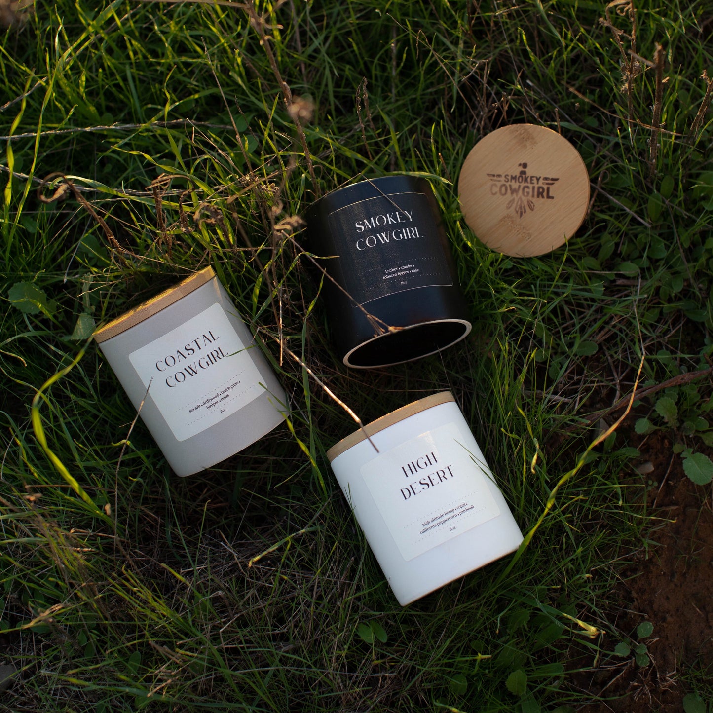 Three candles with labels on a grassy surface