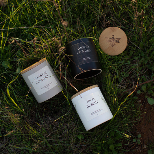 Three candles with labels on a grassy surface