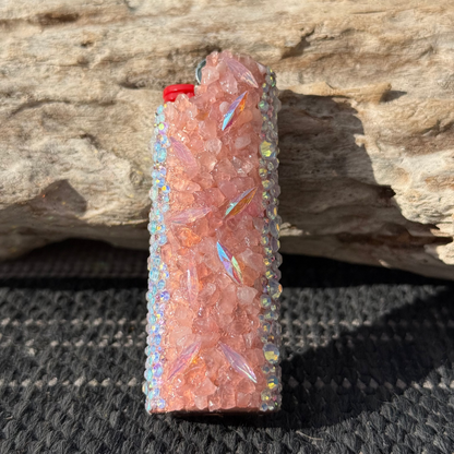 Decorative lighter with gemstone-like embellishments on a wooden surface